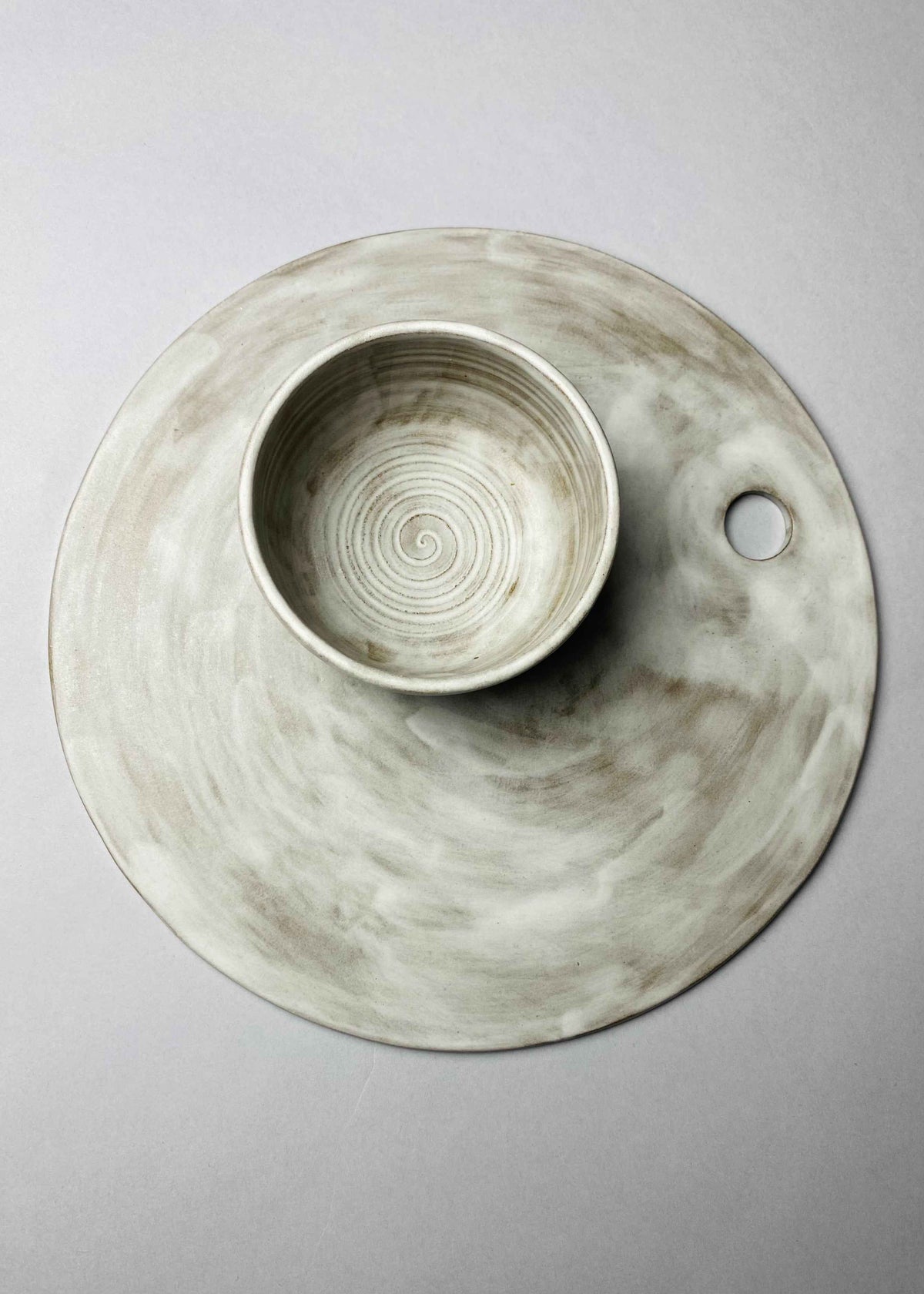 Grey-white ceramic board set with a bowl